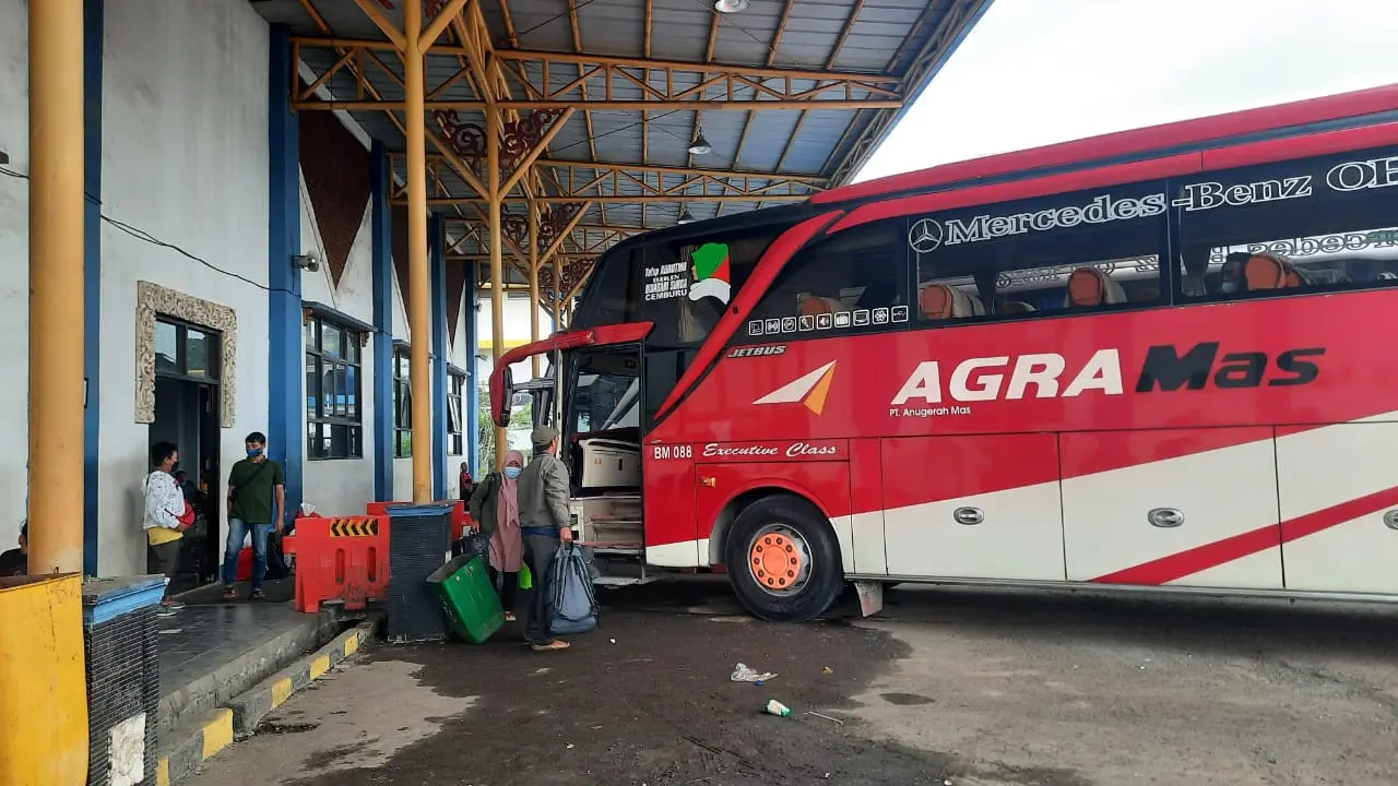 Salah seorang penumpang menggunakan armada bus yang tersedia di Terminal Jatijajar, Kota Depok jelang Lebaran