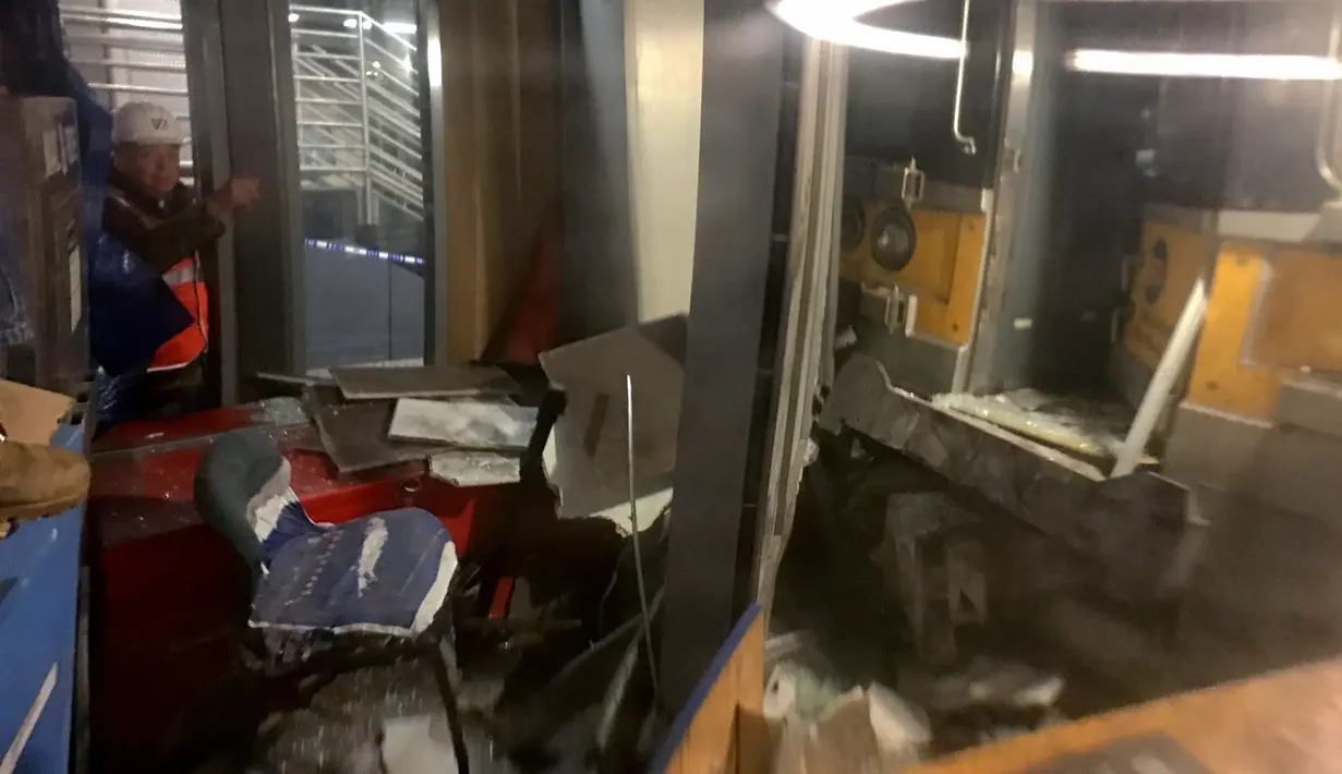 Petugas mengamati kerusakan kereta komuter Long Island Rail Road (LIRR) yang anjlok di Atlantic Terminal di Brooklyn, New York, Rabu (4/1). Kereta gagal berhenti tepat waktu dan menabrak blok dengan kecepatan rendah. (AFP PHOTO/Kena Betancur)