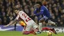 Pemain Chelsea, Willian (kanan) jatuh saat berebut bola dengan pemain Stoke City, Geoff Cameron pada lanjutan Premier League di Stamford Bridge, London (30/12/2017). Chelsea menang 5-0. (AP/Alastair Grant)