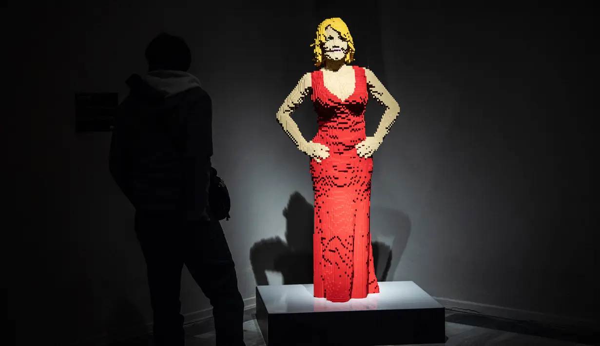 Seseorang berdiri di dekat patung "Courtney Red" yang terbuat dari susunan balok lego pada pameran Art of the Brick di Turin, Italia, Kamis (15/11). Pameran tersebut menampilkan berbagai patung lego karya seniman AS, Nathan Sawaya. (MARCO BERTORELLO/AFP)