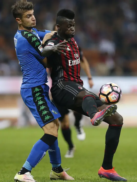 Penyerang AC Milan, Mbaye Niang (kanan) berusaha mengontrol bola dari kawalan gelandang Sassuolo, Luca Mazzitelli pada liga Italia di San Siro, Milan (3/9). AC Milan menang dramatis atas Sassuolo dengan skor 4-3. (AFP Photo/Marco Bertorello)