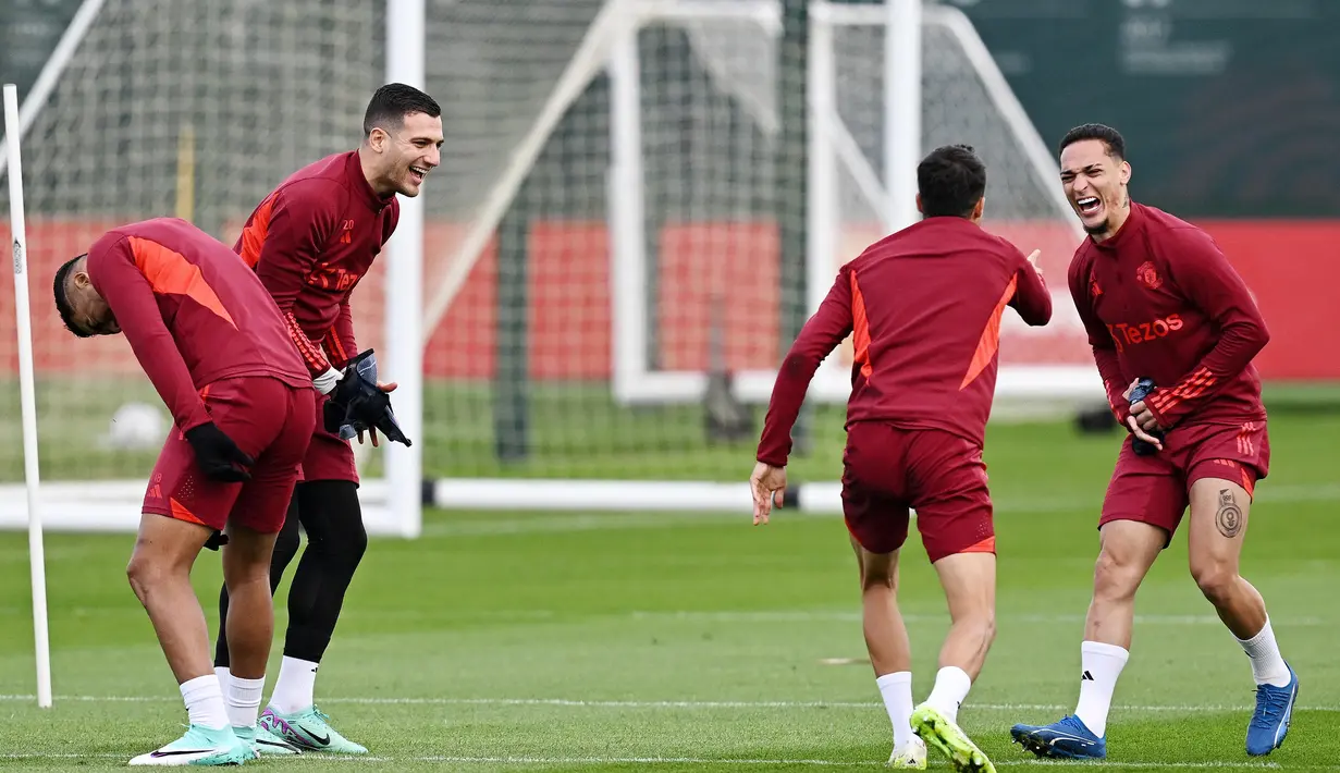 Pemain Manchester United, Casemiro, Diogo Dalot dan Antony tertawa lepas saat sesi latihan di Carrington Training Complex, Senin (23/10/2023). MU akan berhadapan dengan Copenhagen di Liga Champions. (AFP/Paul Ellis)