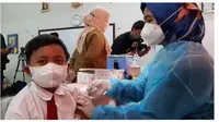 Novaro Alatas (9) siswa SDN Cempaka Putih No 3, Jakarta Pusat mendapatkan vaksin Covid-19 pada hari ini, Selasa (14/12/2021). (Liputan6.com/ Ady Anugrahadi)