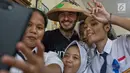 Duta Kehormatan UNICEF, David Beckham berswafoto dengan siswi SMPN 17 Semarang, Sripun dan rekan-rekannya di Jawa Tengah, Rabu (28/3). Kedatangan Beckham di Semarang merupakan rangkaian kegiatan amal yang dilakukannya bersama UNICEF. (Liputan6.com/UNICEF)