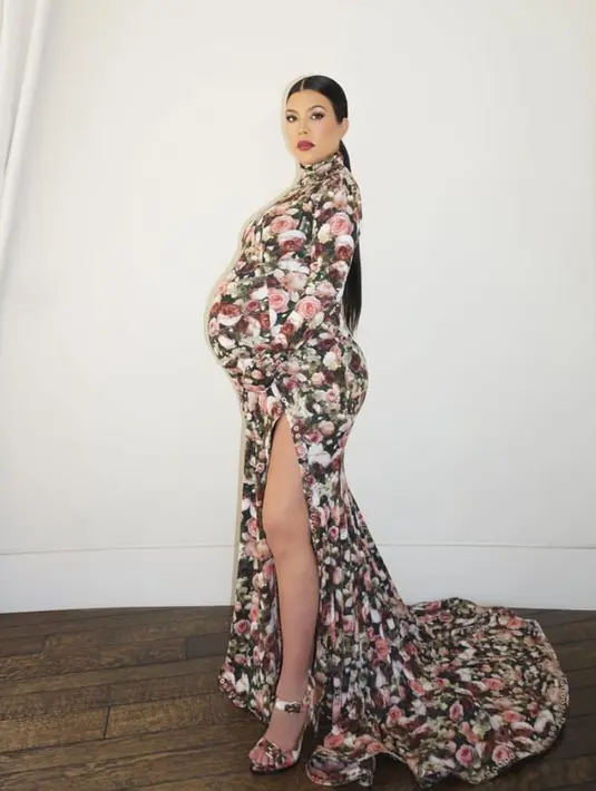 Kourtney Kardashian Barker membagikan foto dirinya berpakaian seperti saudara perempuannya Kim Kardashian. Dengan slit dres motif bunga-bunga.  [@kourtneykardash]