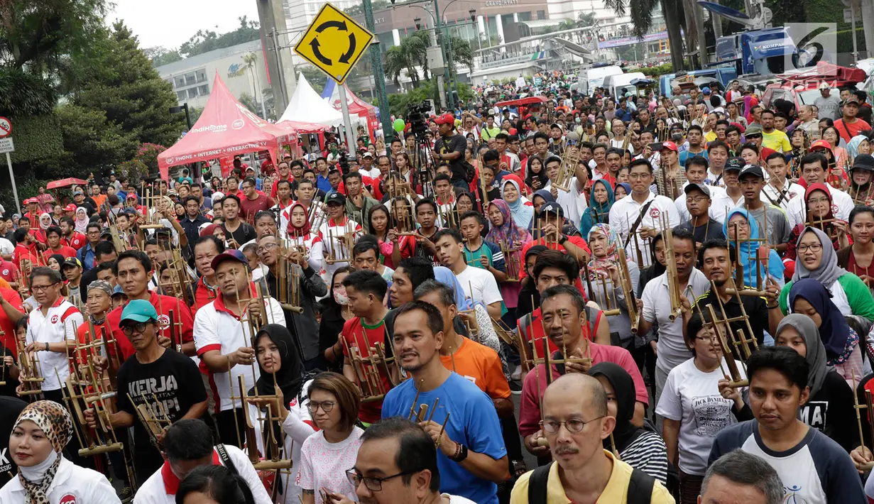 Pengunjung memainkan angklung saat meramaikan acara 'Bangkit Indonesia' di Lokasi Car Free Day (CFD), Jakarta, Minggu (21/5). Acara memperingati Hari Kebangkitan Nasional itu dirayakan dengan pembagian 1.500 angklung. (Liputan6.com/Immanuel Antonius)