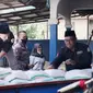 Beberapa jemaah thoriqoh qodariyah wanaqsabandiyah (TQN) Suryalaya yang tergabung dalam pengurus GMPS Suryalaya Cabang Garut, Jawa Barat tengah membagikan  bantuan di lokasi banjir bandang Karangtengah, Garut. (Liputan6.com/Jayadi Supriadin)