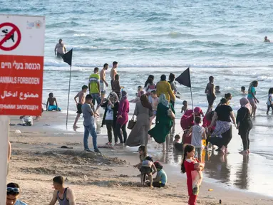 Sejumlah muslim berada di pinggir pantai laut Mediterania ketika menghabiskan libur lebaran di Tel Aviv, Israel, 26 Jni 2017. (AFP PHOTO / JACK GUEZ)