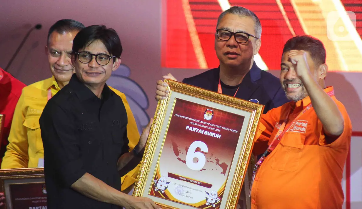 Ketua Umum Partai Buruh Saiq Iqbal (kanan)  menerima nomor urut di gedung KPU, Jakarta, Rabu (14/12/2022). Komisi Pemilihan Umum (KPU) menggelar acara pengundian dan penetapan nomor urut partai politik peserta Pemilu 2024. 17 partai politik yang lolos menjadi peserta Pemilu 2024 pun telah mendapatkan nomor urutnya masing-masing. (Liputan6.com/Herman Zakharia)