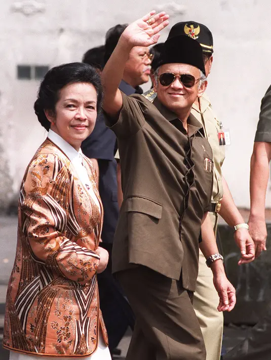 Presiden BJ Habibie didampingi istrinya Ainun Habibie melambaikan tangan kepada wartawan saat tiba di pusat perbelanjaan yang hancur akibat gelombang kekerasan di Chinatown, Jakarta, 26 Mei 1998. Habibie meninggal pada usia 83 tahun akibat gagal jantung dan menua. (AFP Photo/Kemal Jufri)