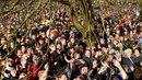 Para peserta berebut bola dekat pohon saat mengikuti Royal Shrovetide Football Match di Ashbourne, Derbyshire, Inggris, Selasa (5/3). Pertandingan ini mempertemukan orang-orang yang terpisah oleh Sungai Derwent di kota tersebut. (Oli Scarff/AFP)