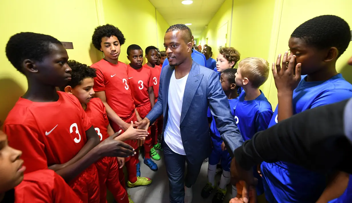 Pemain Timnas Prancis, Patrice Evra, bersama para pemain muda Les Ulis sebelum bertanding, (23/5/2016). (AFP/Franck Fife) 