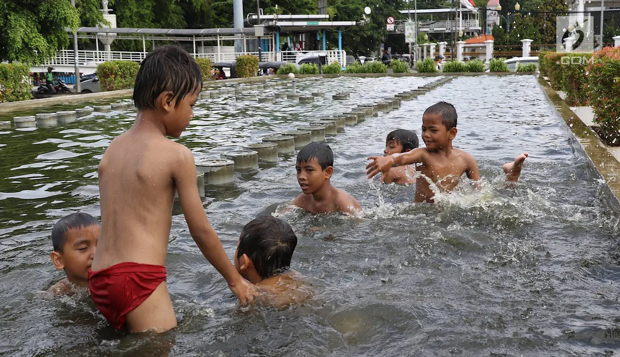 Anak-anak berenang di kolam air mancur penghias kawasan Pasar Baru, Jakarta, Selasa (29/1). Keterbatasan lahan bermain menyebabkan sebagian anak di Ibukota bermain tidak pada tempatnya, meskipun berbahaya bagi keselematan. (Liputan6.com/Immanuel Antonius)