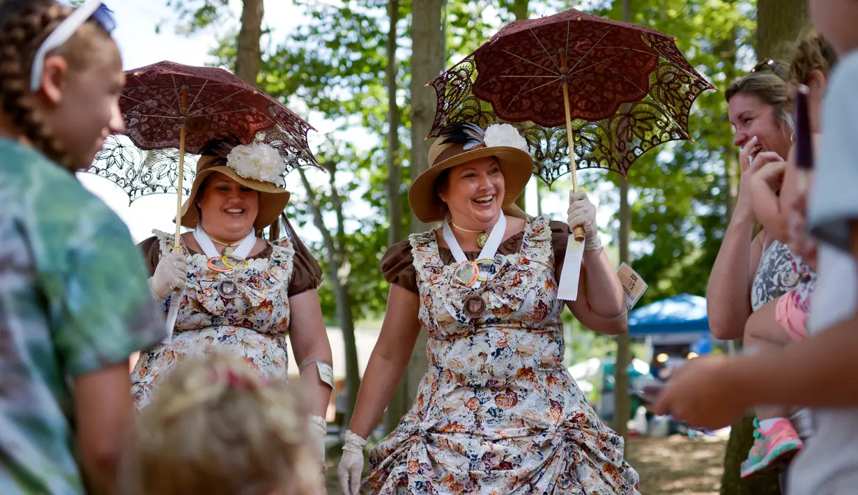 Mary Connors dari Columbus dan saudara kembarnya, Martha Newberry berbincang dengan pasangan kembar lainnya saat Festival Twins Days tahunan ke-42 di Twinsburg, Ohio (5/8). (AFP Photo/Dustin Franz)