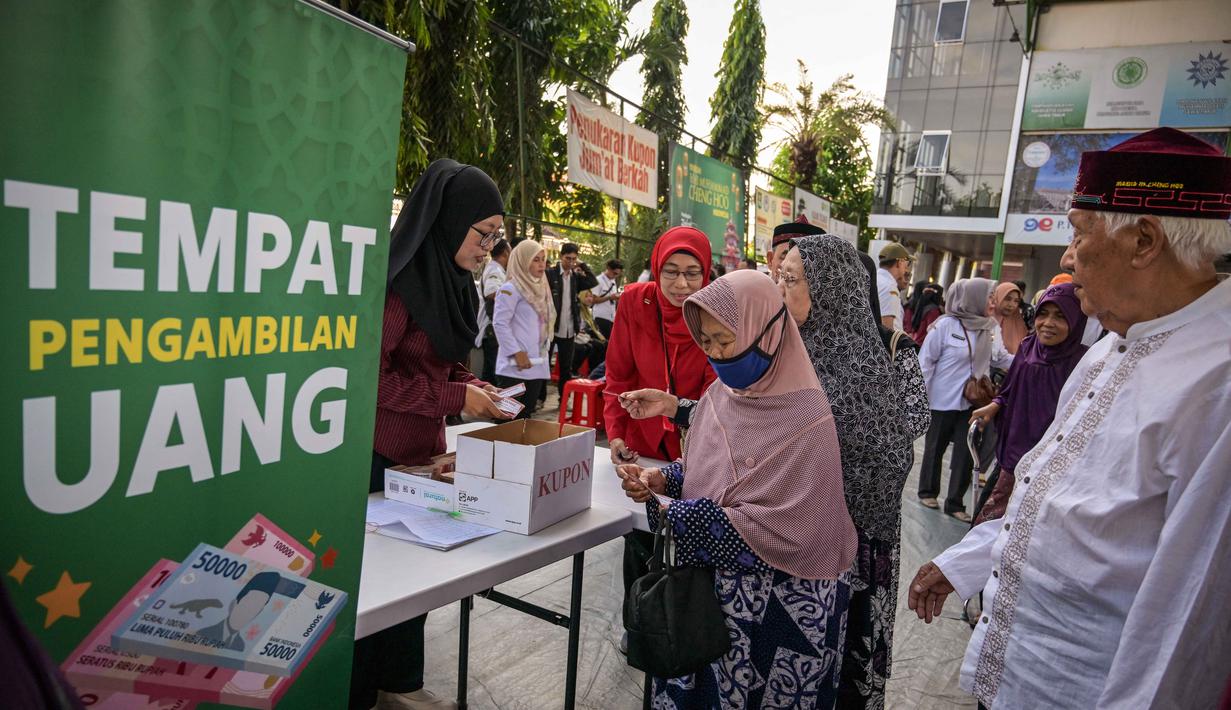 Seorang wanita lanjut usia menerima bantuan uang tunai di masjid Cheng Hoo, Surabaya, Jawa Timur pada Rabu 4 Maret 2026. Ribuan warga Kota Surabaya memadati kawasan Masjid Muhammad Cheng Hoo, Surabaya, Jawa Timur, untuk menerima penyaluran zakat mal. (JUNI KRISWANTO/AFP)