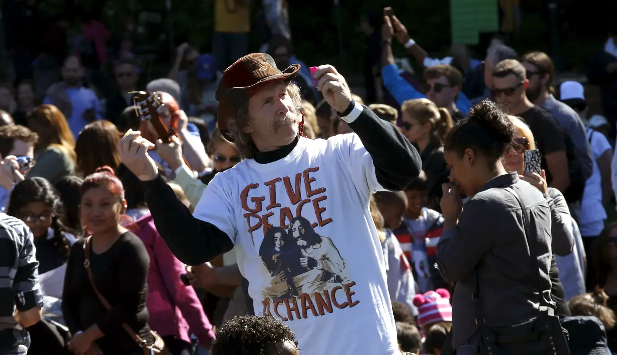 Seorang pria menari saat ia bersama ribuan orang berkumpul untuk membentuk simbol perdamaian raksasa di New York Central Park , Selasa (6/10). Kegiatan yang diprakarsai janda Lennon, Yoko Ono itu menandai ulang tahun John Lennon ke-75.(REUTERS/Mike Segar)