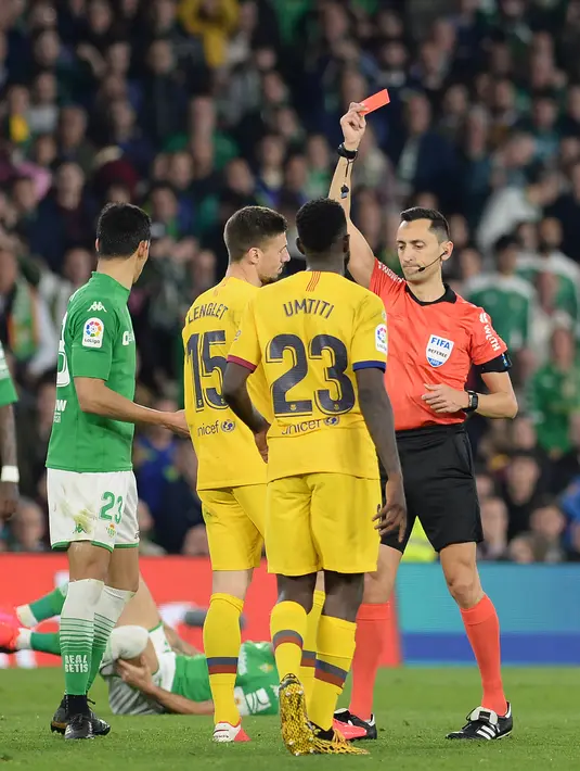 Wasit Sanchez Martinez memberikan kartu merah kepada bek Barcelona, Clement Lenglet pada lanjutan Liga Spanyol pekan ke-23 melawan Real Betis di Benito Villamarin, Minggu (9/2/2020). Diwarnai dua kartu merah, Barcelona mememangkan duel menegangkan lawan Real Betis 3-2. (CRISTINA QUICLER/AFP)