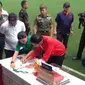 Presiden Joko Widodo membubuhkan tanda tangan di Buku Kurikulum Sepak Bola Indonesia dan Jaket Timnas Indonesia di depan Sekjen PSSI, Ratu Tisha Destria, saat peresmian Lapangan Timnas Indonesia di Senayan, Sabtu (2/12/2017). (Bola.com/Benediktus Gerendo)