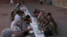 Orang-orang berbuka puasa selama bulan suci Ramadhan di masjid bersejarah Badshahi di Lahore, Pakistan (3/4/2022). Masjid Badshahi merupakan masjid dan sebagai landmark serta tujuan wisata utama kota Lahore. (AP Photo/K.M. Chaudary)