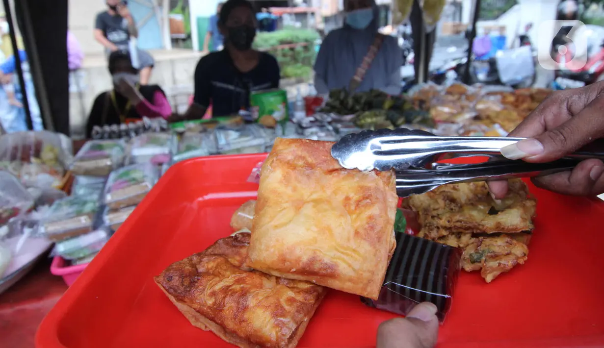 Pembeli memilih makanan untuk berbuka puasa (takjil) di kawasan Pasar Lama, Kota Tangerang, Selasa (20/4/2021). Bulan Ramadhan, membuat sejumlah pedagang takjil musiman bermunculan dan menawarkan aneka makanan dan minuman untuk umat Islam yang menjalankan puasa. (Liputan6.com/Angga Yuniar)