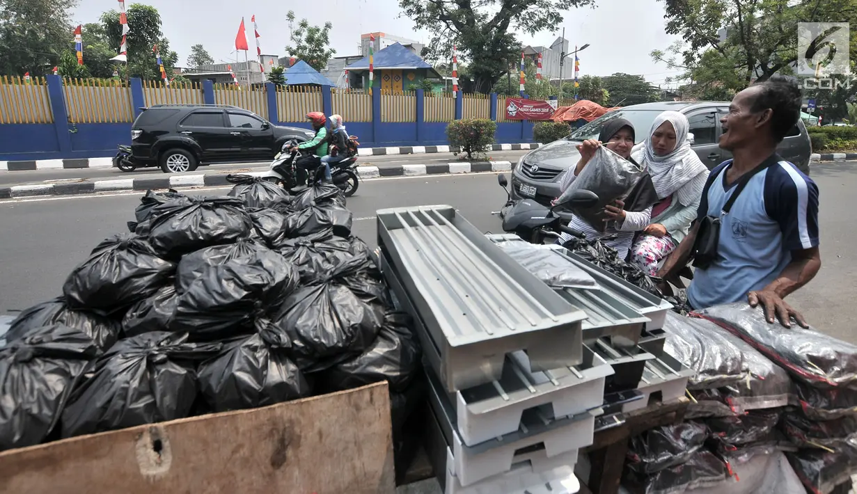 Penjual arang, tusuk sate, dan kotak pemanggang melayani pembeli di kawasan Manggarai, Jakarta, Rabu (22/8). Belasan penjual perlengkapan membuat sate menjamur saat Hari Raya Idul Adha 2018. (Merdeka.com/Iqbal Nugroho)