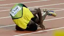 Pelari asal Jamaika, Usain Bolt terkapar di lintasan setelah terjatuh di final 4x100 meter pada Kejuaraan Dunia Atletik di London, Sabtu (12/8). Bolt sempat tertatih-tatih sebelum akhirnya jatuh dan gagal melanjutkan lomba. (AP/Matthias Schrader)