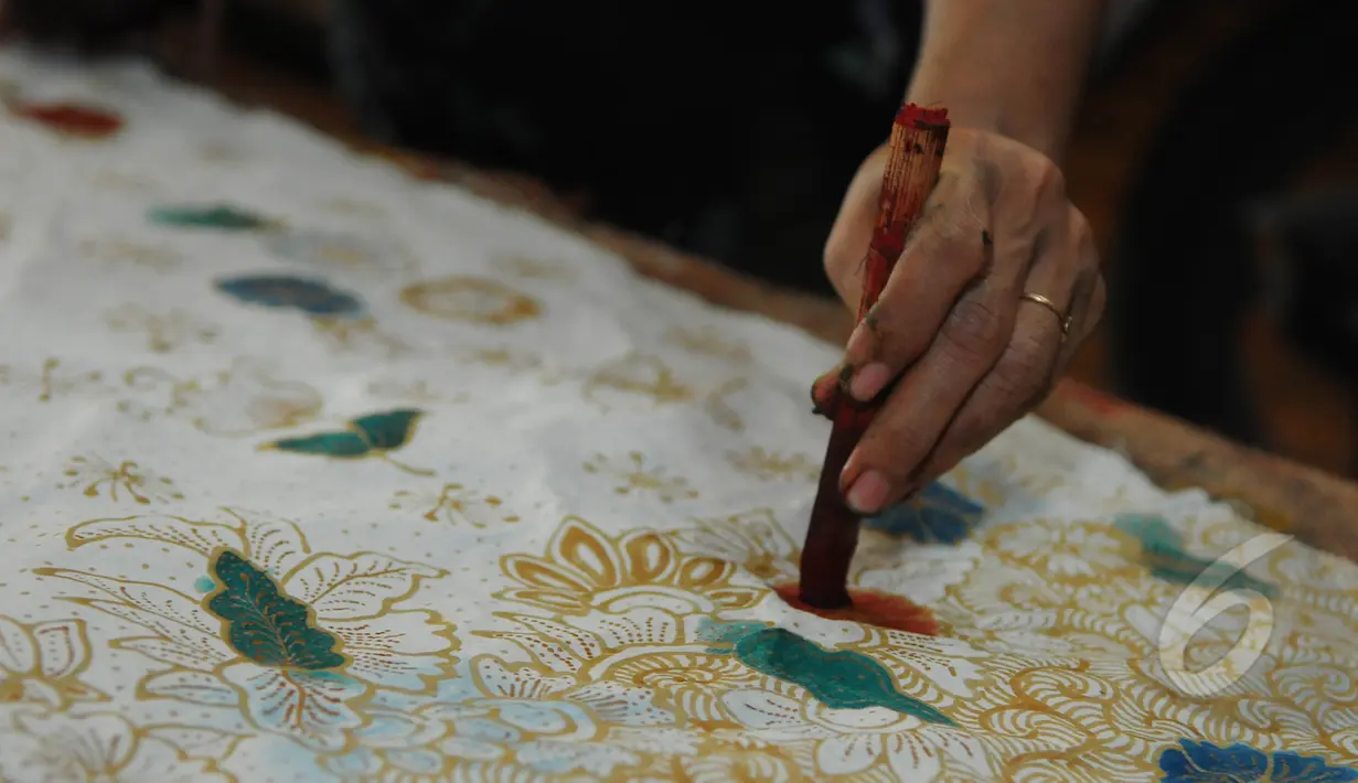 Dibutuhkan ketelitian tingkat tinggi saat proses pewarnaan. Tampak seorang pembatik sedang melakukan proses pewarnaan, Sidoarjo, Jawa Timur, Selasa (24/3/2015). (Liputan6.com/Herman Zakharia)