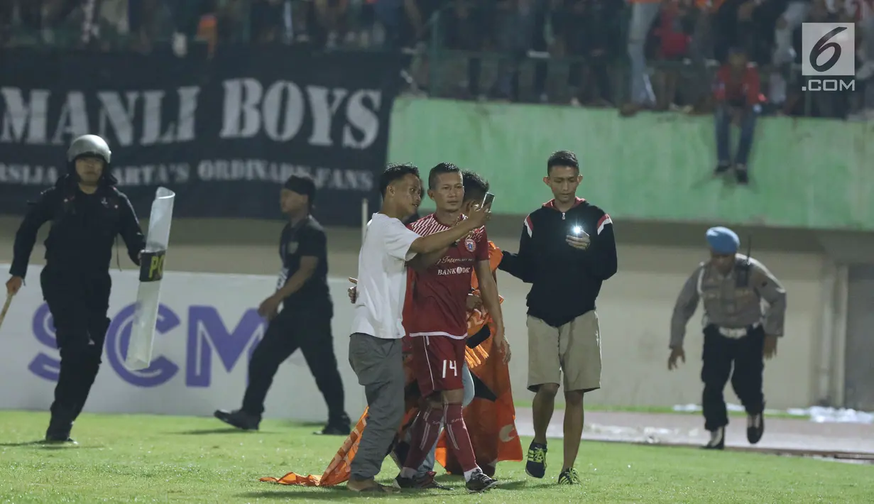 Suporter tim Macan Kemayoran berswafoto dengan pemain Persija, Ismed Sofyan usai laga melawan PSMS di laga pertama semifinal Piala Presiden 2018 di Stadion Manahan, Solo, Jawa Tengah, Sabtu (10/2). (Liputan6.com/Helmi Fithriansyah)