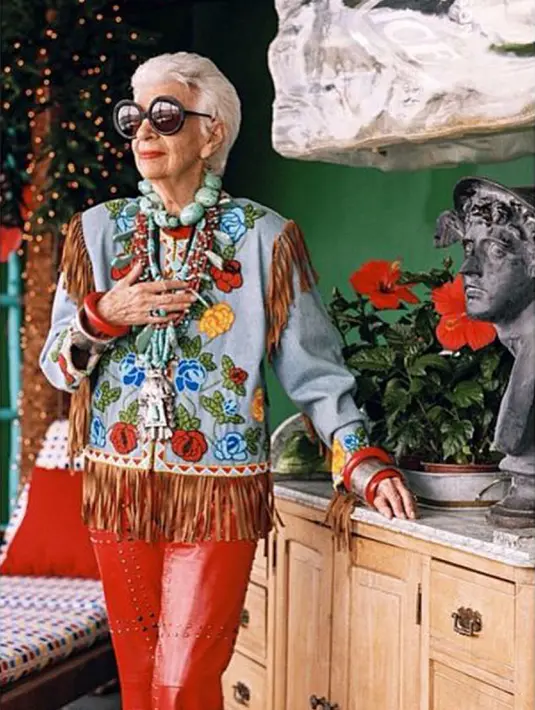 Salah satu gaya busana khas nenek modis berusia 94 tahun itu adalah selalu mengombinasikan aksesori gelang yang menutupi tangan serta kalung manik bebatuan warna-warni yang bertumpuk. (instagram.com/iris.apfel)