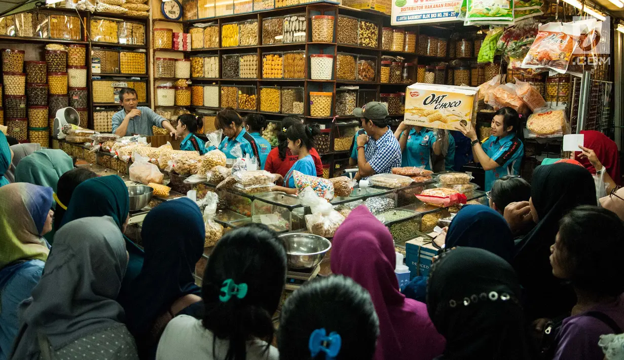 Sejumlah warga mengantre untuk membeli kue kering di toko kue Pasar Jatinegara, Jakarta, Selasa (14/6). Menjelang Hari Raya Idul Fitri 1438 H permintaan kue kering lebaran tersebut mengalami lonjakan hingga 50 % dari biasanya.(Liputan6.com/Gempur M Surya)
