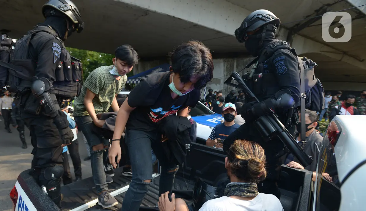 Polisi membawa pelajar yang terjaring razia saat berkumpul di sekitar Gedung DPR/MPR, Jalan Gatot Subroto, Jakarta, Rabu (7/10/2020). Sejumlah akses jalan menuju lokasi dijaga menyusul adanya aksi demonstrasi kelompok buruh yang menolak UU Omnibus Law Cipta Kerja. (merdeka.com/Imam Buhori)