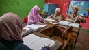 Melalui pendampingan guru, para siswa mempelajari dan memperdalam kemampuan membaca Al Quran menggunakan huruf Braille yang dirancang khusus bagi penyandang tunanetra. Tampak dalam foto, para siswa tunanetra membaca Al-Quran dalam huruf Braille selama bulan suci Ramadan 1447 Hijriah di sebuah sekolah di Surabaya, Jawa Timur, pada 27 Februari 2026. (JUNI KRISWANTO/AFP)