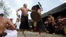 Dua orang laki-laki saling serang saat mengikuti Perang Pandan di Bali (8/6). Tradisi ini merupakan rangkaian upacara keagamaan yang dilakukan ketika upacara Sasih Sembah digelar. (AP/Firdia Lisnawati)