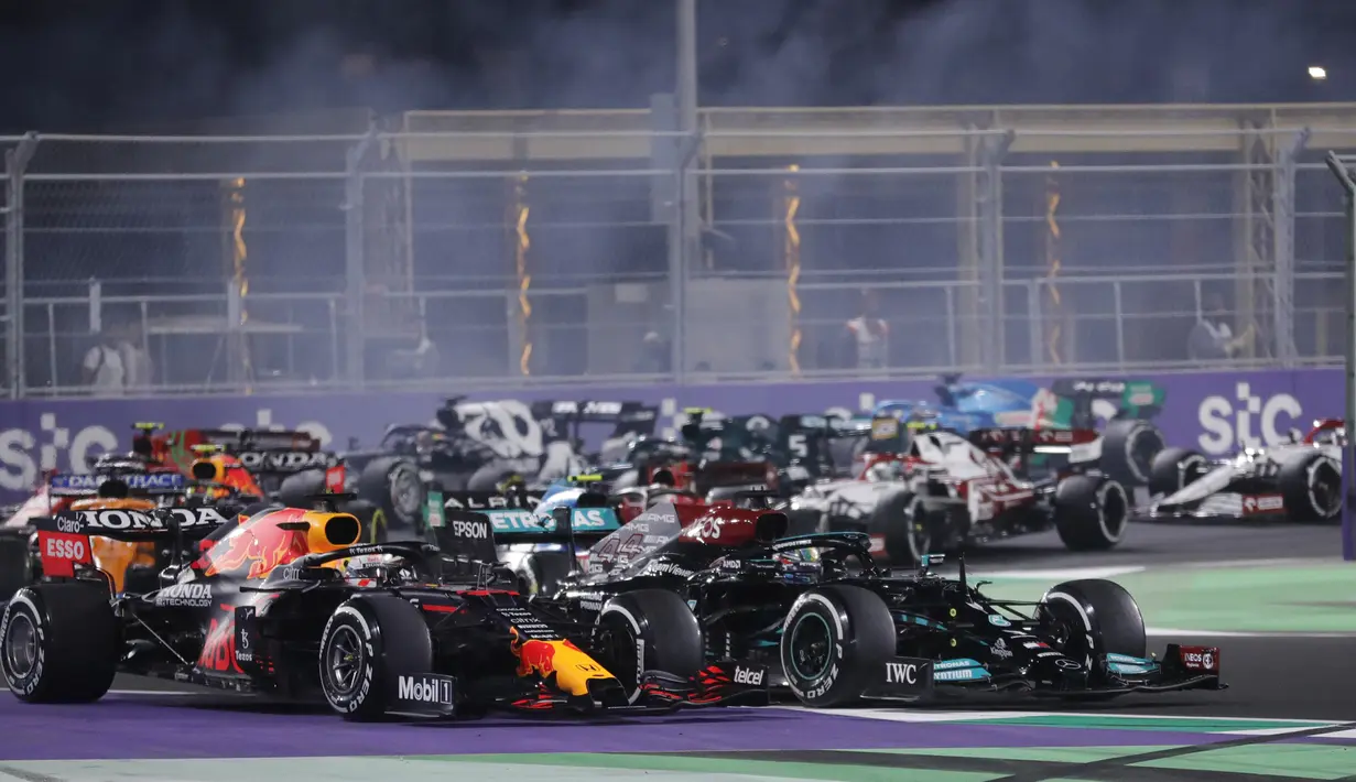 Pembalap Red Bull Max Verstappen (kiri) dan pembalap Mercedes Lewis Hamilton beraksi pada F1 GP Arab Saudi di Jeddah, Minggu, 5 Desember 2021. Kemenangan Lewis Hamilton membuatnya kini menyamai poin Max Verstappen di klasemen F1, yakni 369,5 poin. (AP Photo/Amr Nabil)