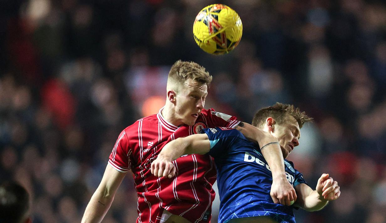 Pemain Bristol City, Ross McCrorie berduel dengan pemain West Ham United, James Ward-Prowse pada laga putaran ketiga Piala FA 2023/2024 di Ashton Gate Stadium, Bristol, Inggris, Rabu (17/01/2024) WIB. (AFP/Adrian Dennis)