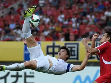 Pemain Korea Selatan, Lee Jongho (kiri) mencetak gol dengan tendangan salto ke gawang Korea Utara dalam Turnamen Piala Asia Timur di Stadion Wuhan Sports Center, Wuhan, Tiongkok. (9/8/2015). (AFP Photo/Wang Zhao)