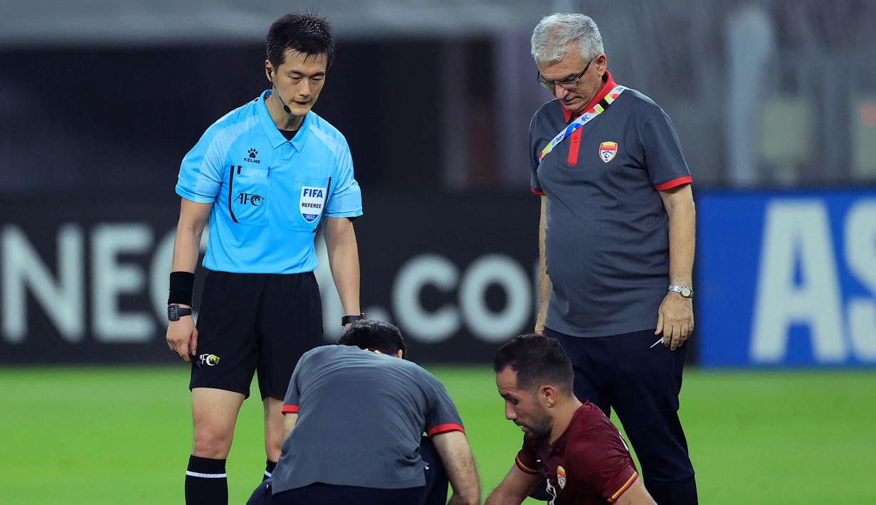 Wasit Ko Hyung-jin memeriksa keadaan pemain Foolad, Mohammad Abshak (R) saat diberikan perawatan medis saat laga Grup C Liga Champions Asia 2023 antara Foolad melawan Al-Gharafa di Prince Abdullah bin Faisal Stadium, Jeddah, Arab Saudi, 7 April 2022. (AFP)