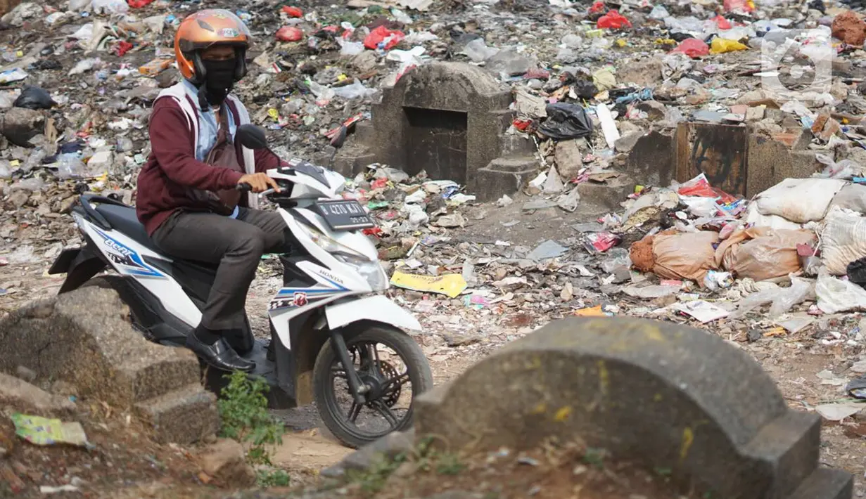 Pengendara motor melintas di sekitar Taman Pemakaman Umum (TPU) Menteng Pulo, Jakarta, Selasa (3/12/2019). Pemprov DKI Jakarta berencana merevitalisasi 17 TPU serta akan melakukan perluasan lahan makam hingga 794,83 hektar. (Liputan6.com/Immanuel Antonius)