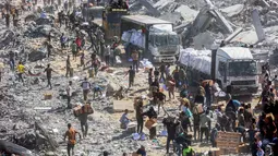 Pasca pemberlakukan kesepakatan gencatan senjata antara Israel dan Hamas pada Jumat 10 Oktober 2025, warga memadati kawasan Khan Younis untuk mengumpulkan bantuan yang masuk melalui pos perbatasan Karem Abu Salem, bagian selatan Jalur Gaza, pada Minggu 12 Oktober 2025. (Omar AL-QATTAA/AFP)