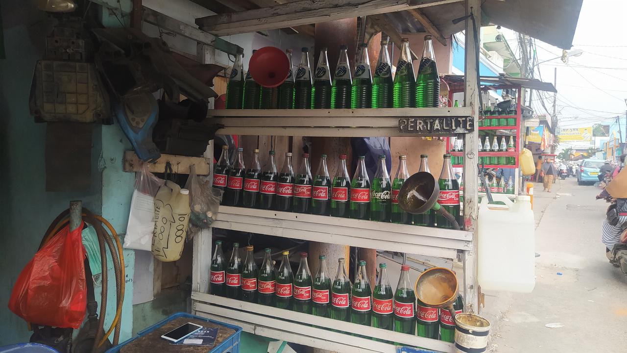 Penjual bensin eceran. Kenaikan harga BBM atau Bahan Bakar Minyak seperti risiko yang harus ia hadapi berjualan bensin.