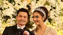 Nabila Syakieb tampak sangat cantik mengenakan gaun pengantin panjang berwarna putih layaknya seorang puteri. Di sampingnya sang suami pun tampil gagah dan tampan dengan jas pengantin berwarna hitam. (Fathan Rangkuti/Bintang.com)
