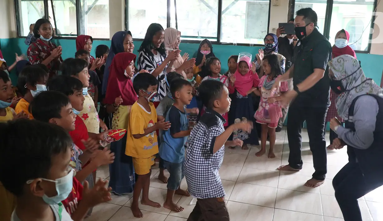 Direktur PAUD Institute Danang Sasongko (kiri) dan karyawan Askrindo menghibur anak-anak korban banjir dengan bermain, bernyanyi dan menari bersama di Kantor Kecamatan Cilamaya Wetan, Cikampek Jumat (12/02/2021). (Liputan6.com/Pool/Askrindo)
