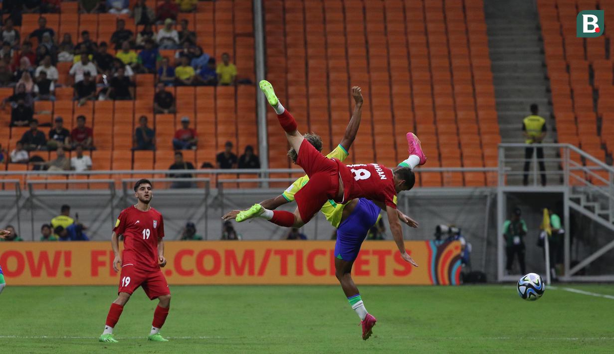 <p>Pemain Timnas Iran U-17, Mahan Sadeghi (depan) berduel udara dengan pemain Timnas Brasil U-17, Pedro Lima pada laga pertama Grup C Piala Dunia U-17 2023 di Jakarta International Stadium (JIS), Jakarta, Sabtu (11/11/2023). (Bola.com/Ikhwan Yanuar)</p>