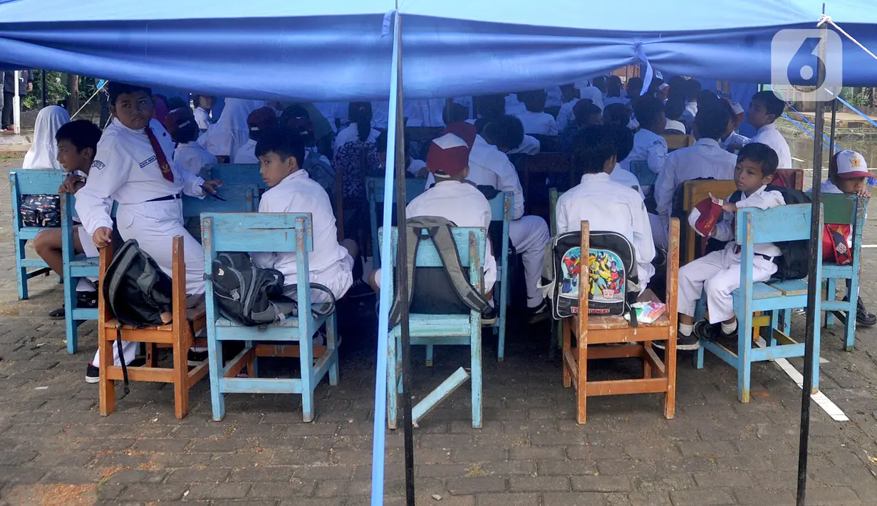 Murid-murid mengikuti kegiatan belajar di dalam tenda darurat di SDN Cirimekar 2, Cibinong, Bogor, Senin (6/1/2020). Hari ini merupakan hari pertama murid sekolah melakukan kegiatan belajar mengajar (KBM) paska libur tahun baru dan bencana banjir yang melanda kawasan Jabotabek. (merdeka.com/Arie Bas