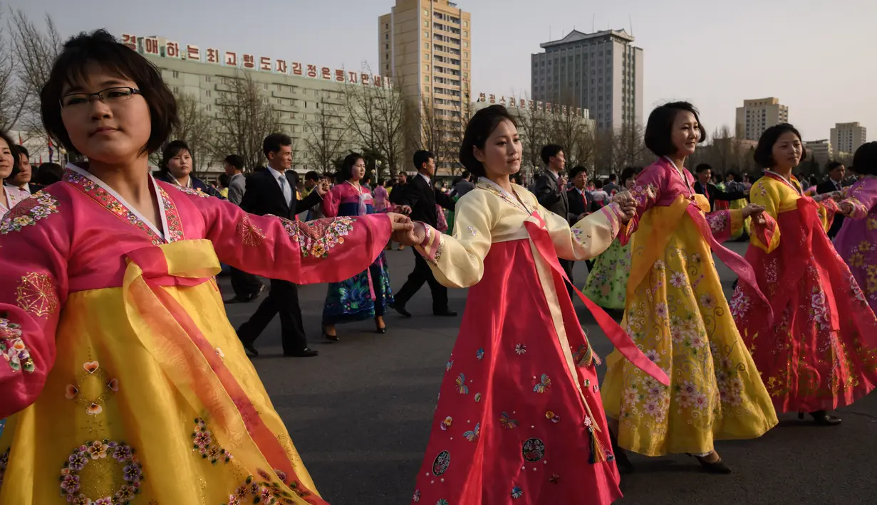 Sejumlah siswa mengenakan pakaian tradisional melakukan tarian massal di luar Stadion Indoor Pyongyang, Korea Utara (9/4). Mereka melakukan tarian massal untuk menghormati pemimpin mereka Kim Jong Il. (AFP Photo/Ed Jones)