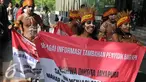Sejumlah pemuda Papua mengenakan pakaian adat membawa spanduk berunjuk rasa di depan Gedung KPK, Jakarta, Senin (19/12). Mereka meminta KPK mengusut kasus korupsi pejabat yang mencalonkan diri pada Pilkada Jayapura 2017. (Liputan6.com/Helmi Affandi)