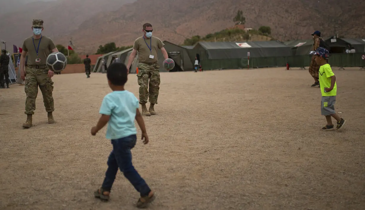 Anak-anak bermain sepak bola dengan pasukan militer AS di rumah sakit militer selama latihan militer Singa Afrika di Tafraout, Maroko, Kamis (10/6/2021). Dengan lebih 7.000 peserta dari sembilan negara dan NATO, Singa Afrika adalah latihan terbesar Komando Afrika AS. (AP Photo/Mosa'ab Elshamy)