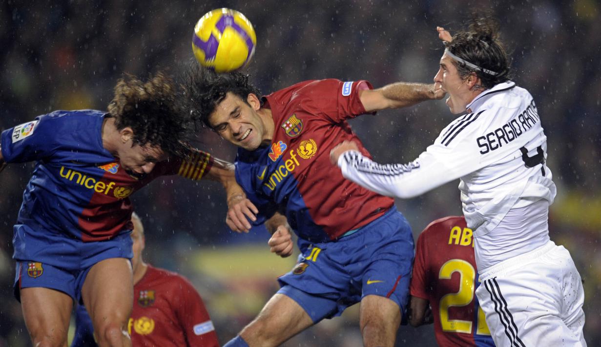 Bek Barcelona, Rafael Marquez, duel udara dengan bek Real Madrid, Sergio Ramos, pada laga La Liga di Camp Nou, Sabtu (13/12/2014). Eks bintang Barcelona ini mendapat sanksi dari Departemen Keuangan AS karena kasus narkoba. (AFP/Philippe Desmazes)