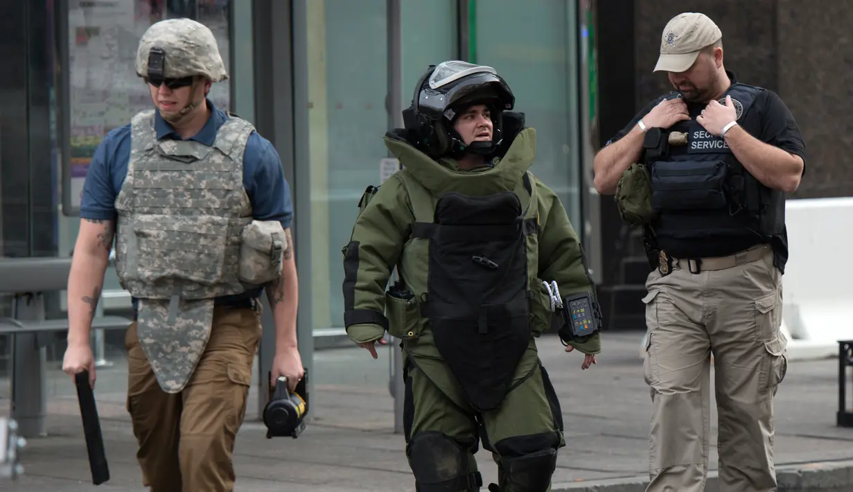 Penjinak bom berjalan usai mengambil paket mencurigakan di dekat Hilton Garden Hotel di Washington, DC.AS (19/1). Sekitar 28.000 pasukan keamanan akan berjaga saat pelantikan Presiden terpilih AS, Donald Trump. (AFP Photo/Andrew Caballero-Reynolds)