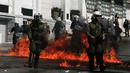 Sejumlah polisi anti huru-hara melawan aksi demonstran yang melemparkan bom api di Athena, Yunani, (12/11/2015). Para Demonstran memprotes langkah-langkah penghematan yang diminta oleh badan pinjaman internasional. (REUTERS/Alkis Konstantinidis)